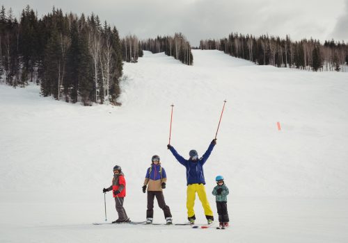 Family having fun while skiing during winter